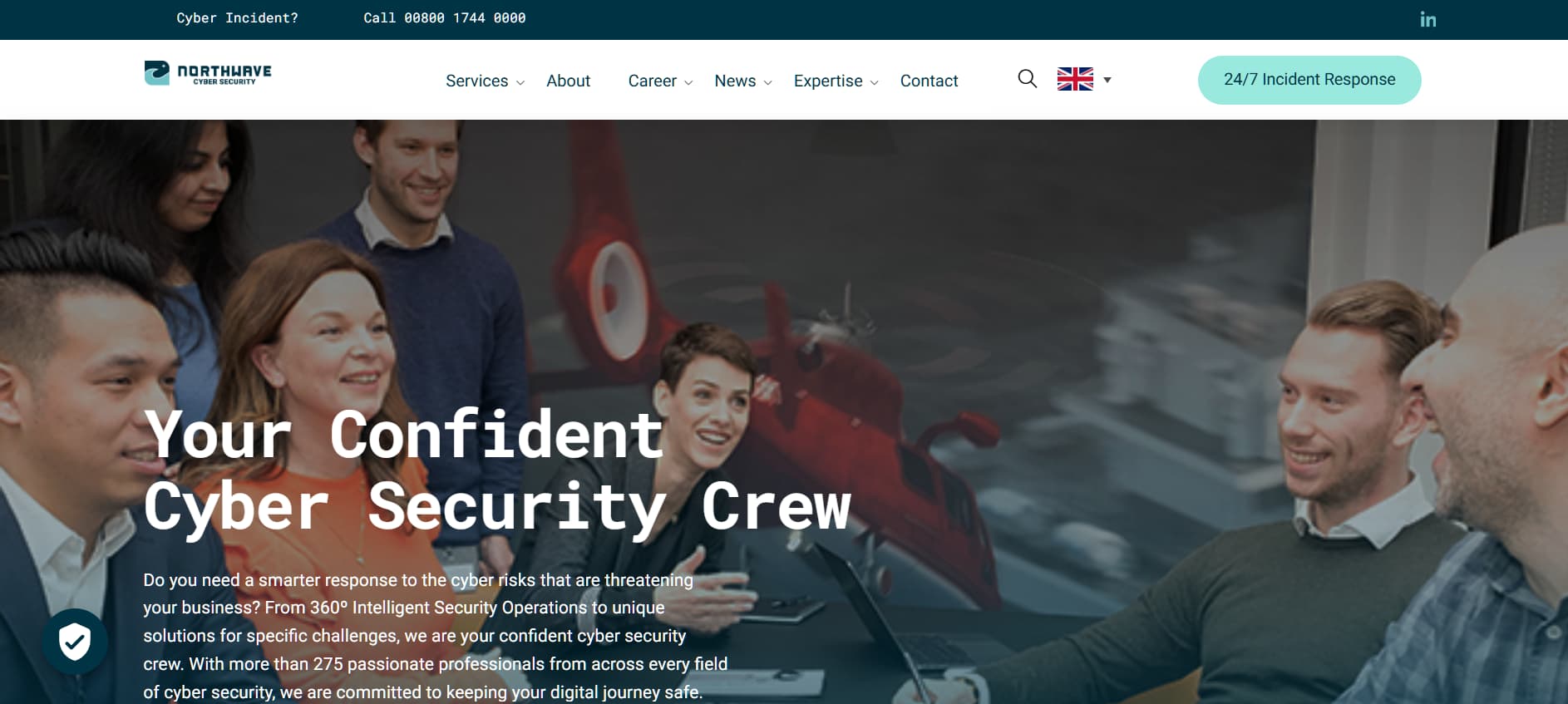 Team meeting scene in an office with multiple professionals smiling and talking, overlaid with the text “Your Confident Cyber Security Crew.”