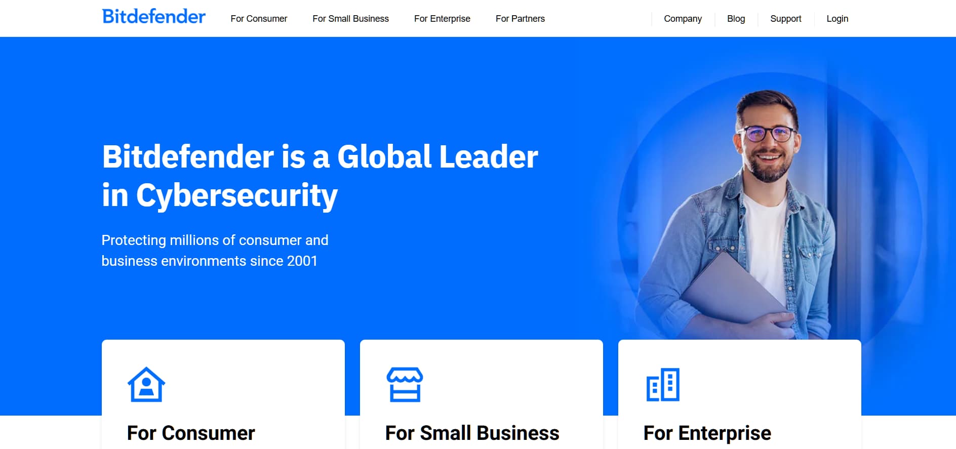 Alt: “Bitdefender homepage with blue background, smiling professional holding laptop, and sections for consumer, small business, and enterprise.”