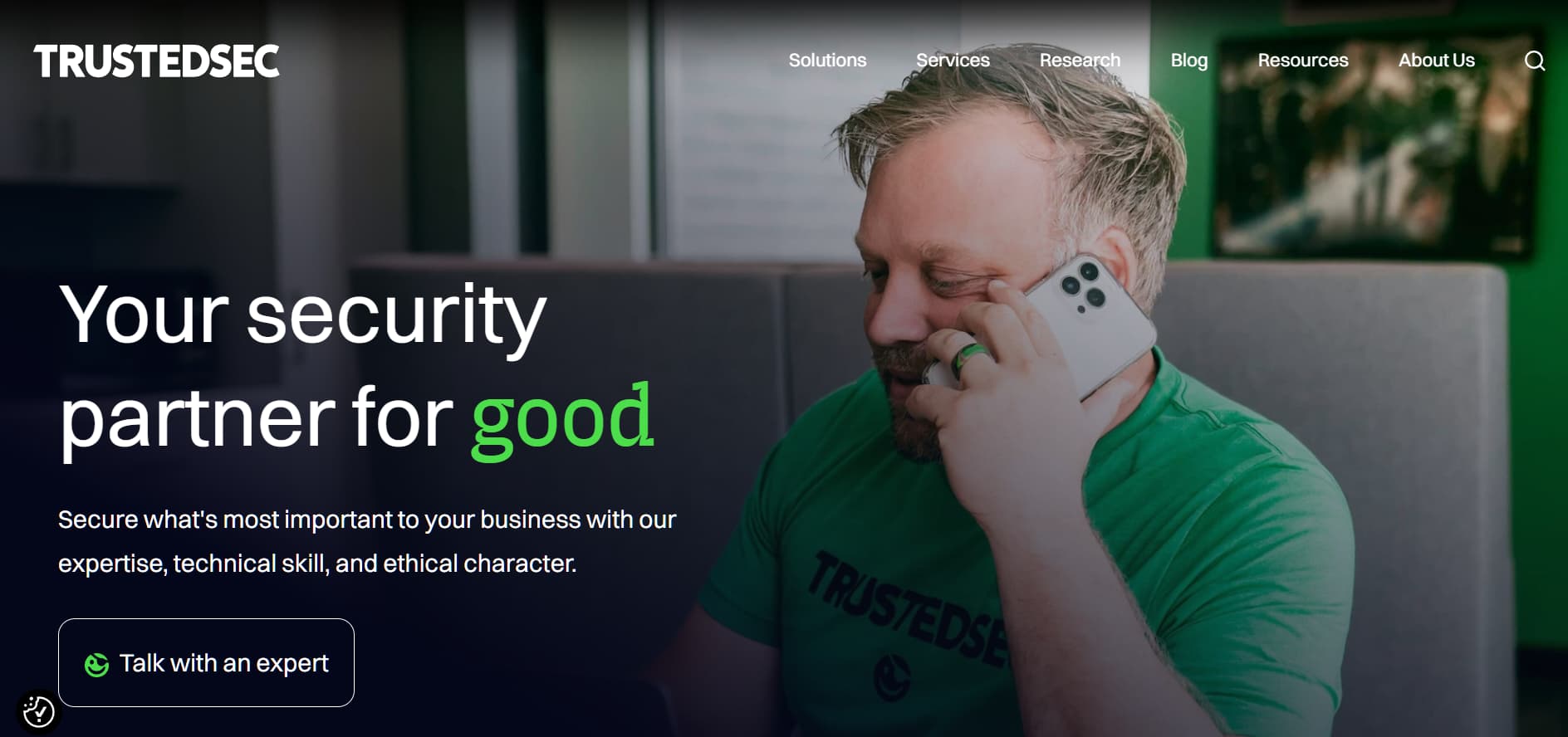 TrustedSec cybersecurity consulting website hero with security expert on phone and partner for good slogan
