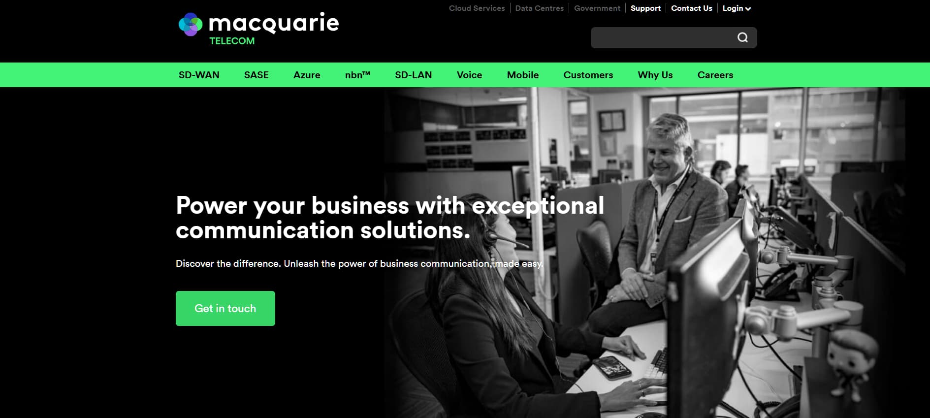 “Macquarie Telecom homepage showing a black-and-white office scene with employees wearing headsets, and the headline ‘Power your business with exceptional communication solutions.’”
